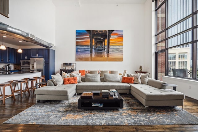 living room with a high ceiling and dark wood-type flooring