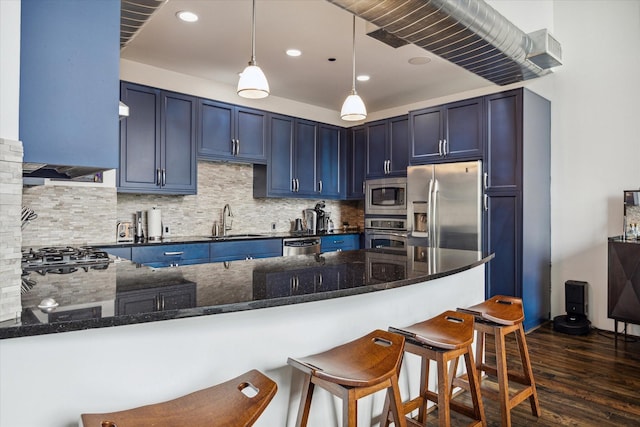 kitchen with decorative backsplash, kitchen peninsula, blue cabinetry, and stainless steel appliances