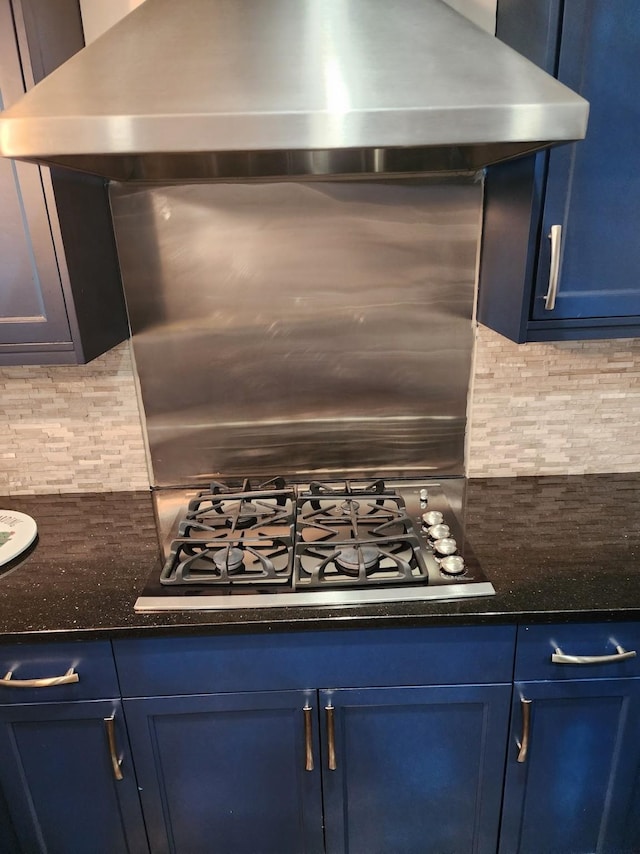 kitchen with blue cabinetry, tasteful backsplash, wall chimney range hood, and stainless steel gas stovetop