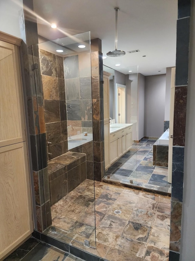 bathroom featuring vanity and tiled shower