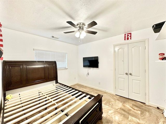 unfurnished bedroom with a textured ceiling, a closet, and ceiling fan