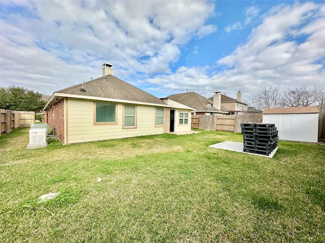 rear view of house featuring a yard, a patio, and a shed