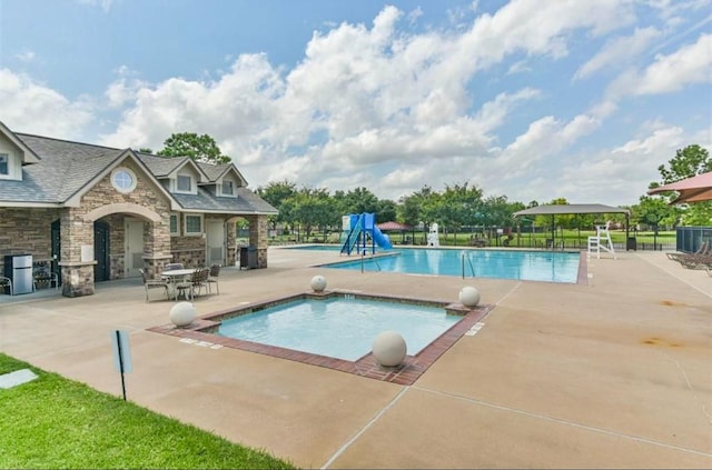 view of pool with a patio and a water slide