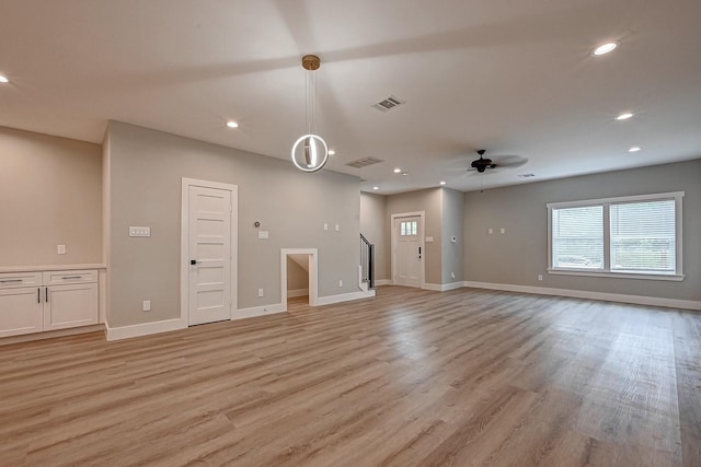 unfurnished living room featuring ceiling fan and light hardwood / wood-style flooring