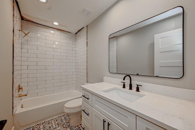 full bathroom featuring tile patterned flooring, tiled shower / bath combo, toilet, and vanity