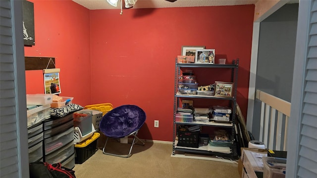 interior space featuring carpet, a textured ceiling, and ceiling fan