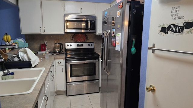 kitchen featuring white cabinets, sink, light tile patterned floors, tasteful backsplash, and stainless steel appliances