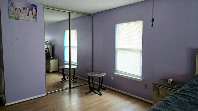 bedroom featuring a textured ceiling, light hardwood / wood-style flooring, and a closet