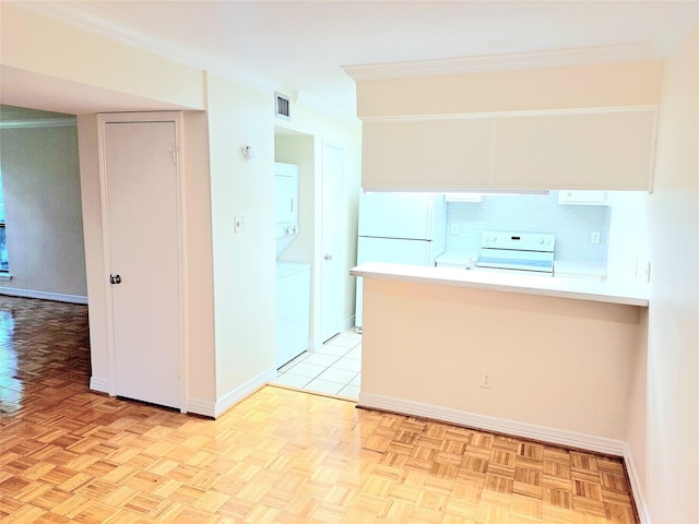 kitchen with stacked washer / drying machine, stove, ornamental molding, and light parquet floors