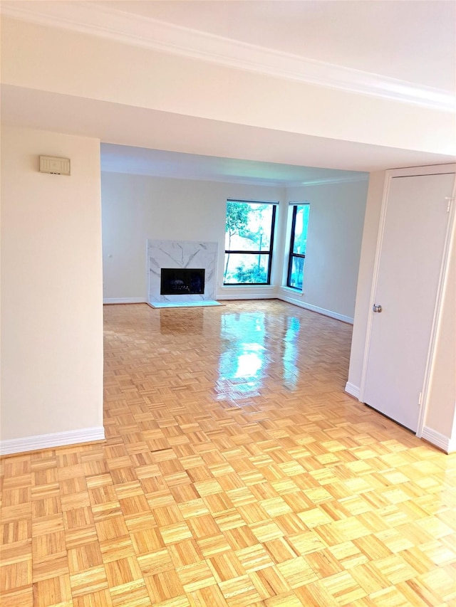 unfurnished living room featuring a high end fireplace and light parquet floors