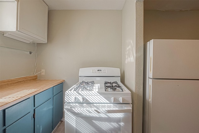 kitchen with white cabinets, white appliances, and blue cabinets