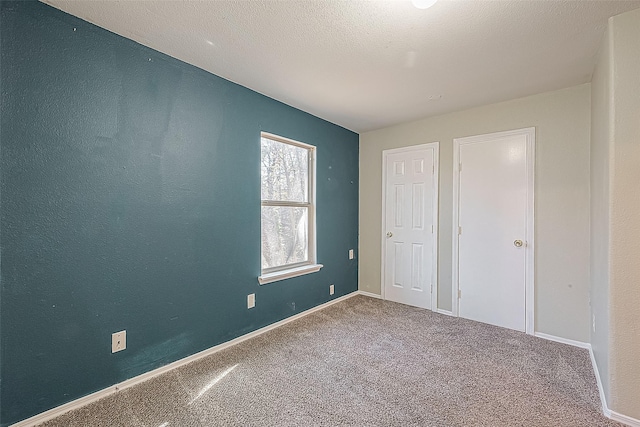 unfurnished bedroom featuring carpet and a textured ceiling