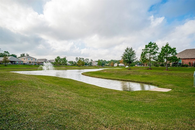 surrounding community with a water view and a lawn