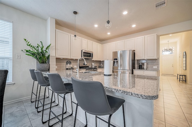 kitchen featuring white cabinets, sink, hanging light fixtures, kitchen peninsula, and stainless steel appliances