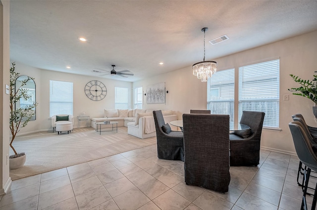 dining area featuring light tile patterned floors and ceiling fan with notable chandelier