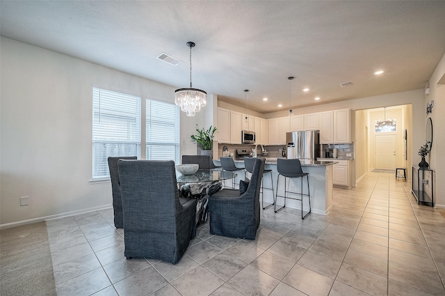 tiled dining room featuring an inviting chandelier