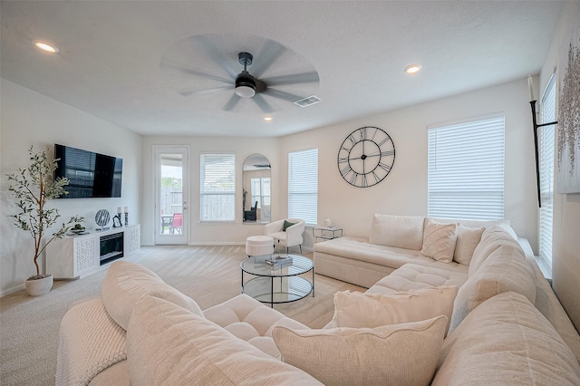 living room featuring light carpet and ceiling fan