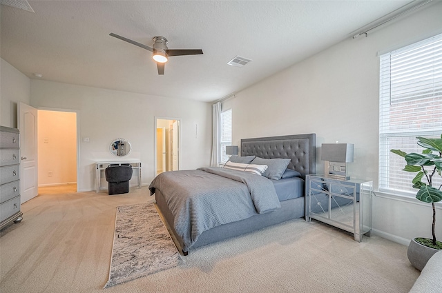 carpeted bedroom featuring connected bathroom and ceiling fan