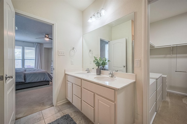 bathroom with tile patterned flooring, vanity, and ceiling fan