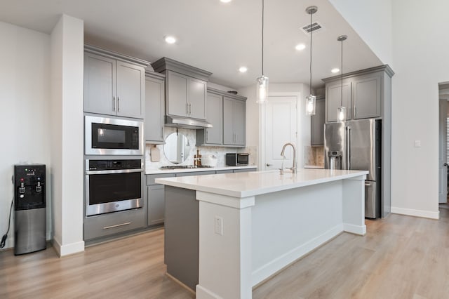 kitchen with pendant lighting, gray cabinetry, and appliances with stainless steel finishes