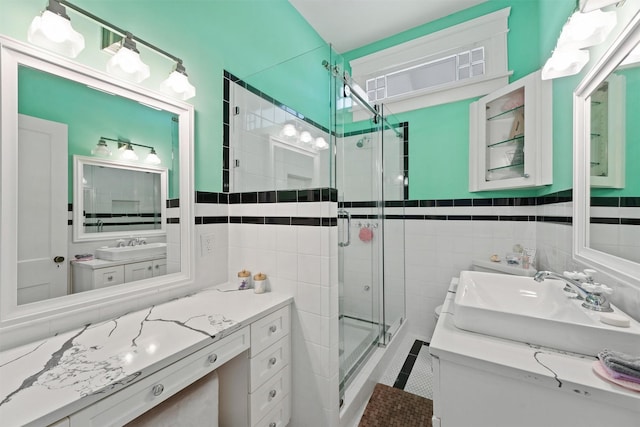 bathroom featuring vanity, a shower with door, and tile walls