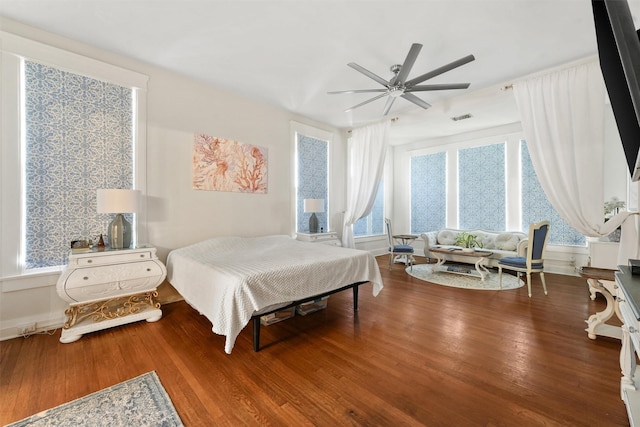 bedroom featuring ceiling fan, wood-type flooring, and multiple windows