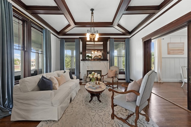 sitting room featuring hardwood / wood-style floors, coffered ceiling, a wealth of natural light, and a chandelier