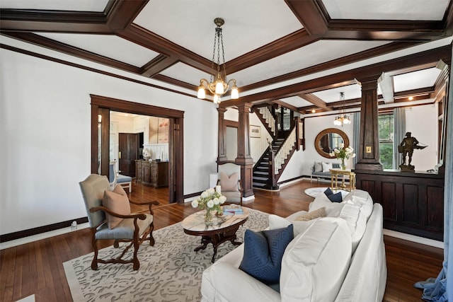 living room featuring an inviting chandelier, dark hardwood / wood-style floors, ornate columns, and crown molding