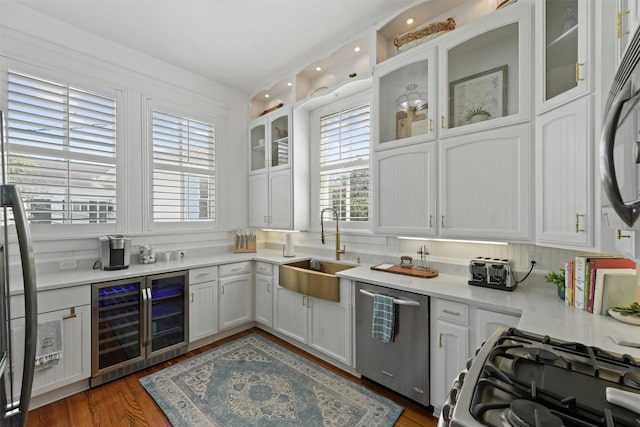 kitchen featuring dark wood-type flooring, white cabinets, sink, wine cooler, and stainless steel appliances