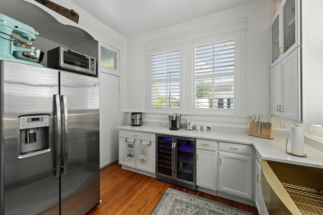 bar with stainless steel refrigerator with ice dispenser, white cabinetry, wine cooler, and wood-type flooring