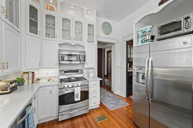 kitchen featuring white cabinetry, hardwood / wood-style floors, and appliances with stainless steel finishes