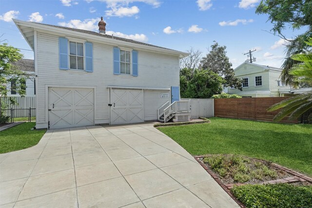 view of side of home featuring a lawn and a garage