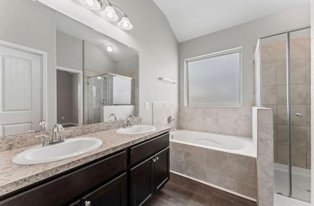 bathroom with hardwood / wood-style flooring, vanity, lofted ceiling, and shower with separate bathtub