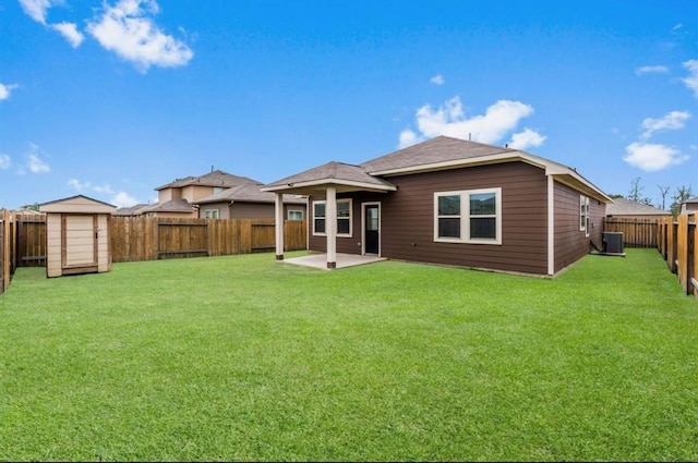 back of house featuring central air condition unit, a patio area, a yard, and a storage unit