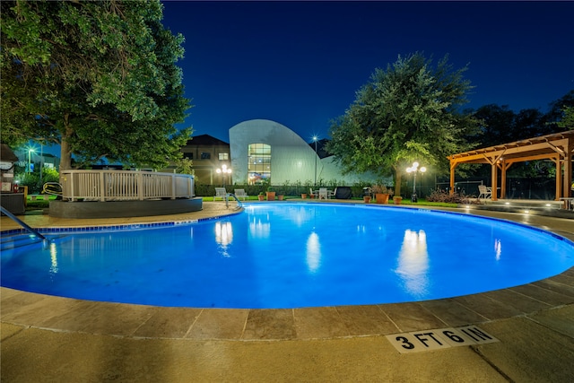 pool at twilight featuring a pergola