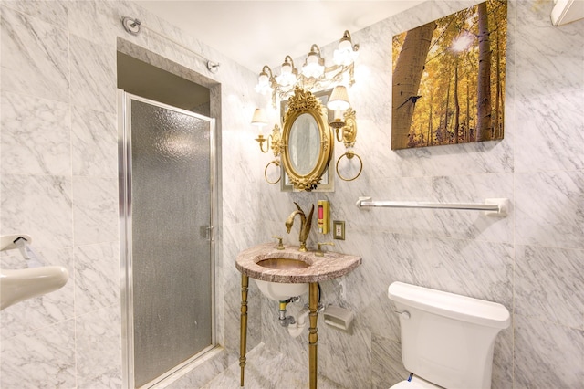 bathroom featuring toilet, tile walls, a shower with shower door, and sink