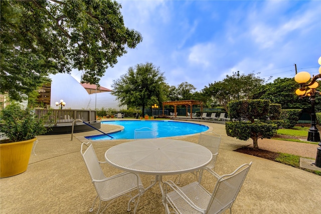 view of pool featuring a patio and a wooden deck