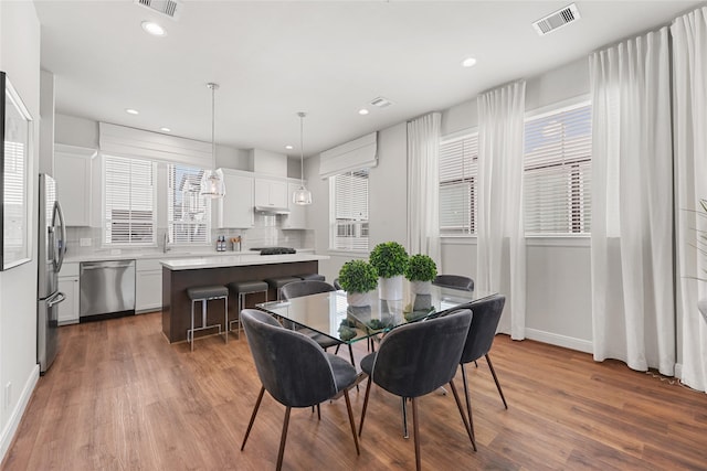 dining space with hardwood / wood-style floors and a healthy amount of sunlight