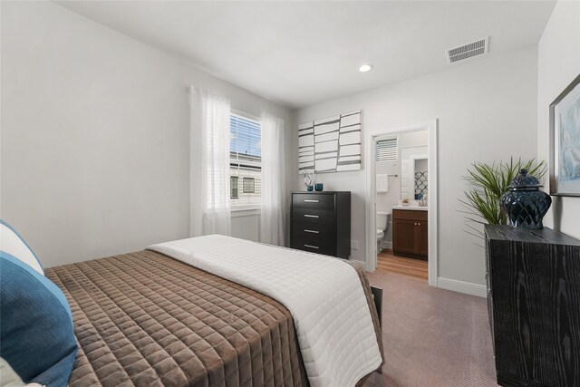 carpeted bedroom featuring ensuite bathroom