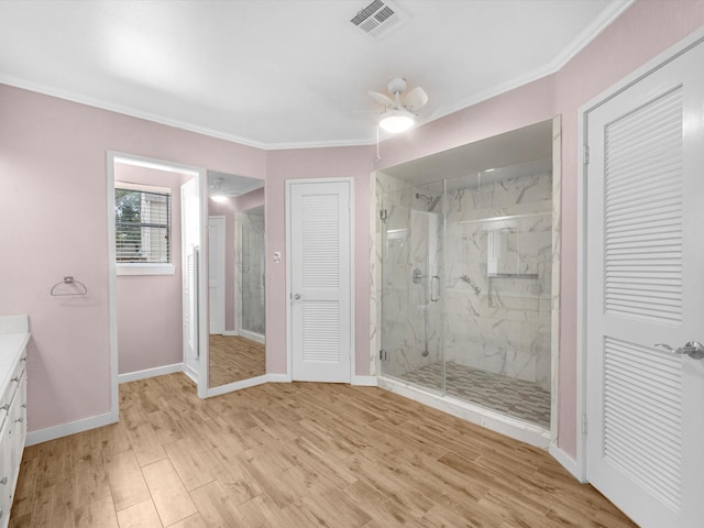 bathroom featuring ceiling fan, hardwood / wood-style flooring, vanity, and ornamental molding