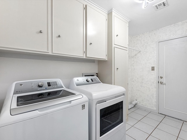 laundry room with cabinets, light tile patterned floors, and independent washer and dryer