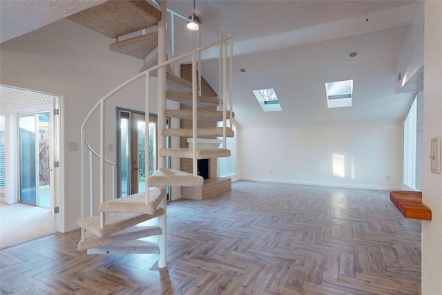 stairs featuring a fireplace, parquet floors, and lofted ceiling with skylight