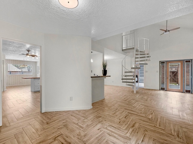 unfurnished living room with light parquet flooring and a textured ceiling