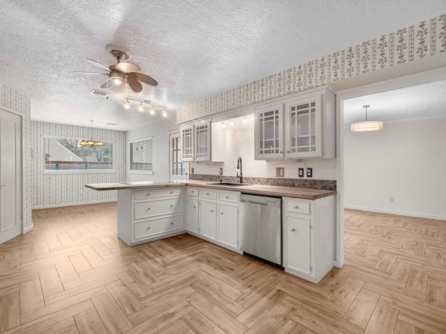 kitchen featuring dishwasher, white cabinetry, sink, hanging light fixtures, and ceiling fan