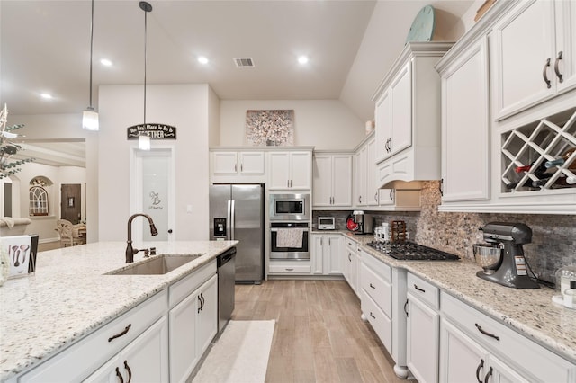 kitchen featuring decorative backsplash, stainless steel appliances, sink, pendant lighting, and white cabinetry