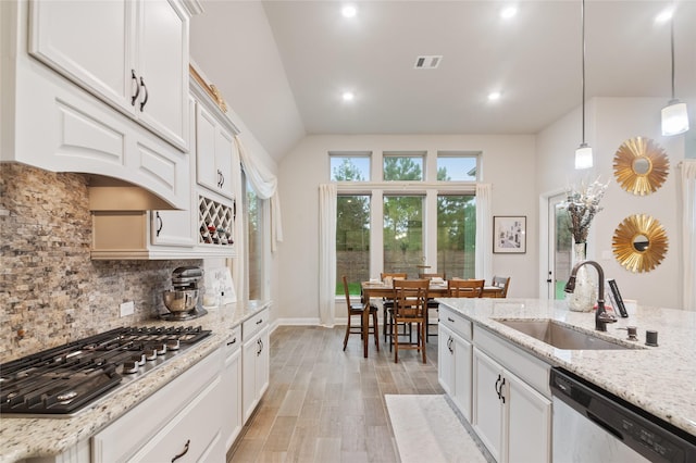 kitchen with white cabinets, gas stovetop, sink, decorative light fixtures, and dishwasher