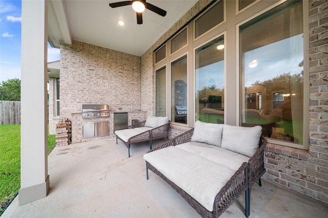 view of patio / terrace with area for grilling, ceiling fan, and an outdoor kitchen