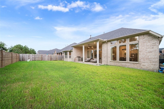 back of house featuring a yard, ceiling fan, and a patio area