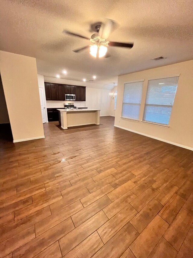 12209 Renewal Way, Houston, TX 77047 - unfurnished living room featuring ceiling fan with notable chandelier and a textured ceiling