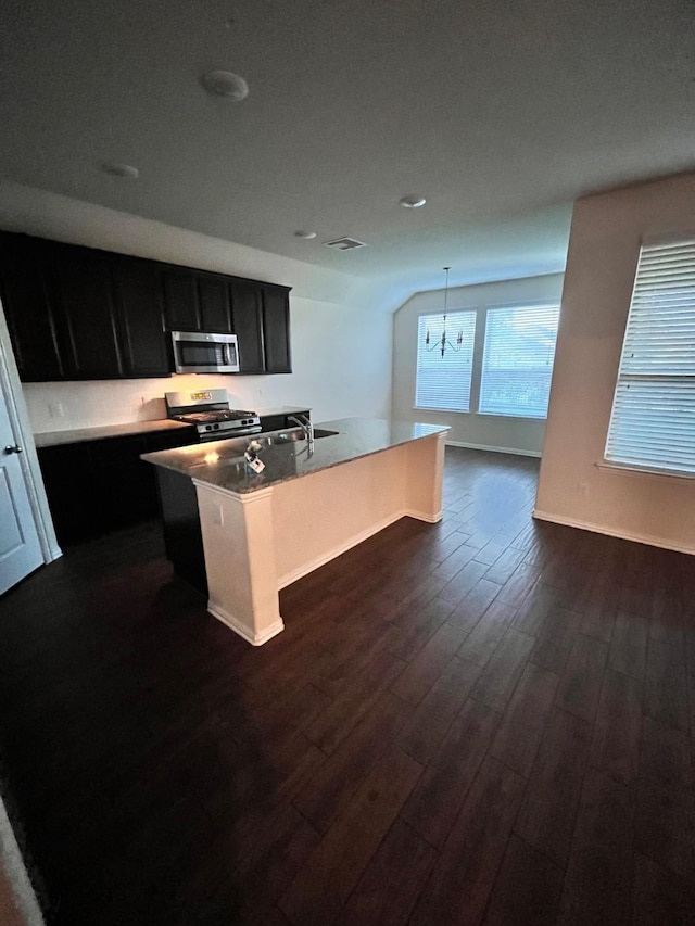12209 Renewal Way, Houston, TX 77047 - kitchen featuring lofted ceiling, hanging light fixtures, dark hardwood / wood-style floors, an island with sink, and stainless steel appliances